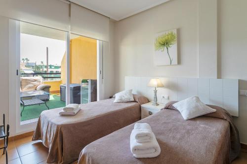 a hotel room with two beds and a balcony at Chalet Bonalba Golf in Alicante