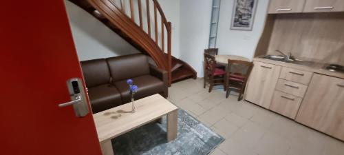 a living room with a couch and a table and a kitchen at Valenciennes appart in Valenciennes