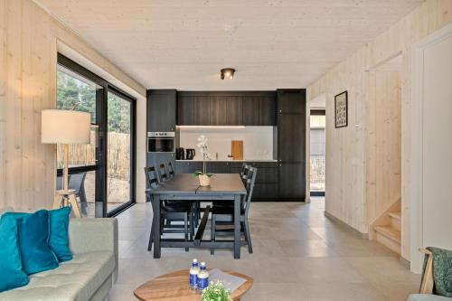 eine Küche und ein Wohnzimmer mit einem Tisch und Stühlen in der Unterkunft Chalet Florette in Koksijde