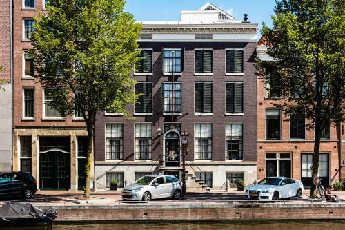 two cars parked in front of a brick building at Hotel 717 in Amsterdam