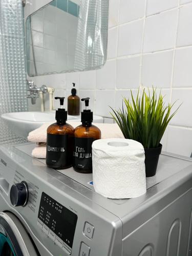 uma máquina de lavar roupa com duas garrafas de sabão e toalhas em 2х комнатная квартира в центре города Уральска em Oral