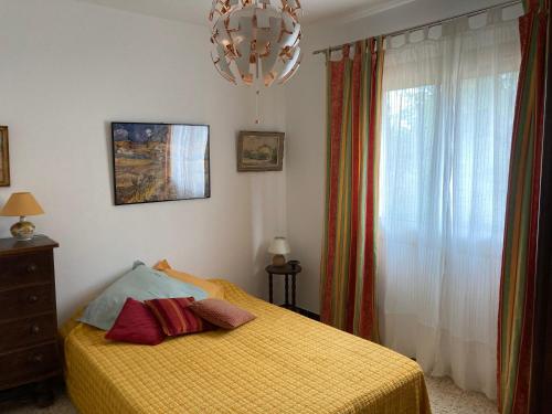 - une chambre avec un lit jaune et un lustre dans l'établissement Haut de villa avec terrasse privative jardin et parking tout près des plages, à Toulon