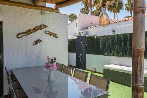 een eetkamer met een glazen tafel en stoelen bij Ca Martina Sonora Golf in Maspalomas