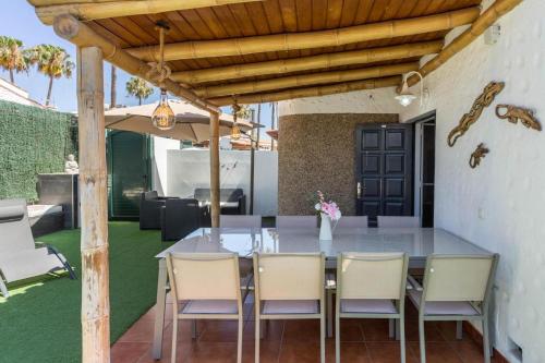 een buiteneetkamer met een tafel en stoelen bij Ca Martina Sonora Golf in Maspalomas