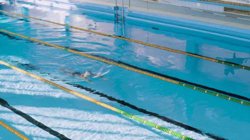 a woman swimming in a swimming pool at Holiday Inn Express Mianyang High-Tech Zone, an IHG Hotel in Mianyang