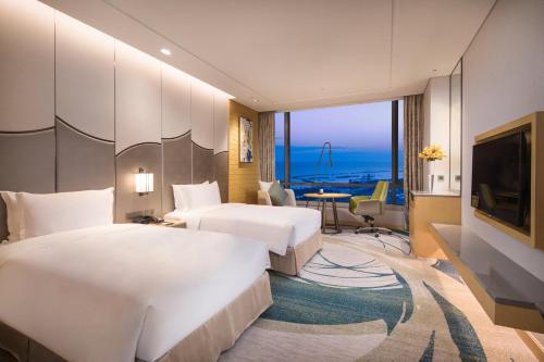 Cette chambre comprend deux lits et une télévision. dans l'établissement Holiday Inn Suzhou Taihu Lake, an IHG Hotel, à Suzhou
