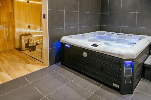 a bathroom with a large bath tub in a room at Rákóczi Hotel, Tábor és Rendezvényközpont in Sátoraljaújhely