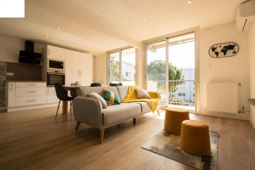 un salon avec un canapé et une cuisine dans l'établissement 005- Appartement 6 chambres, Tramway, Parking,Clim, à Montpellier