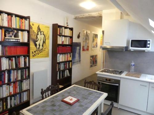 eine Küche mit einem Tisch und einem Bücherregal mit Büchern in der Unterkunft B2 Appartement entier centre ville tout confort in Courtenay