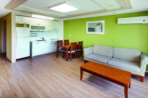 a living room with a couch and a table and a kitchen at Hanwha Resort Pyeongchang in Pyeongchang 