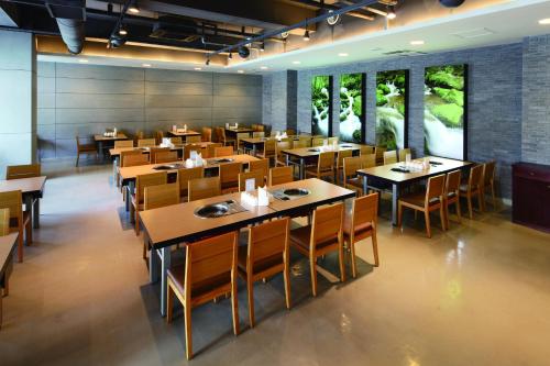 a restaurant with wooden tables and chairs and windows at Hanwha Resort Pyeongchang in Pyeongchang