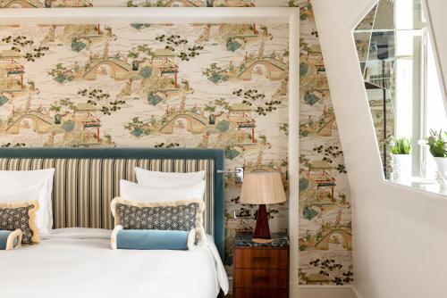 a bedroom with a bed and a wall covered in wallpaper at Saint James Paris in Paris