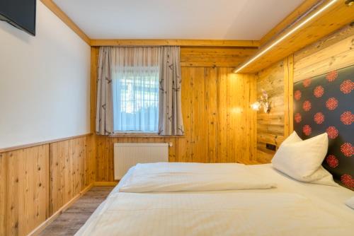 a bedroom with a large bed in a room with wooden walls at Appartement Hofmann in Königsleiten