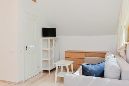 a living room with a couch and a table at Sengirės kotedžai Juodkrantė in Juodkrantė