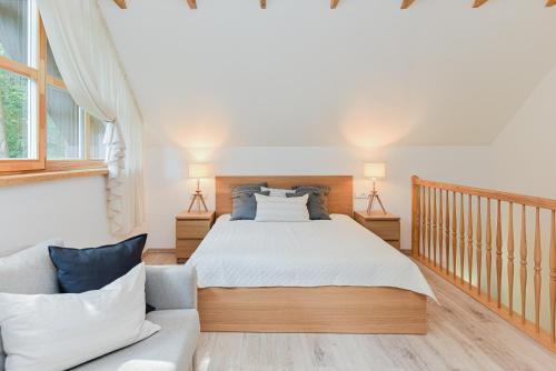 a bedroom with a bed and a couch at Sengirės kotedžai Juodkrantė in Juodkrantė