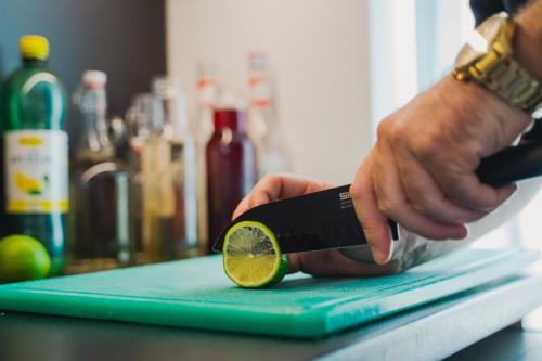 a person cutting a lime on a cutting board at Rákóczi Hotel, Tábor és Rendezvényközpont in Sátoraljaújhely
