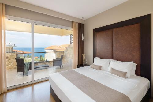 a bedroom with a large bed and a balcony at Blue Bay Halkidiki in Afitos