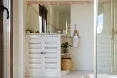 baño con armario blanco y espejo en Vista Catedral, en Sevilla