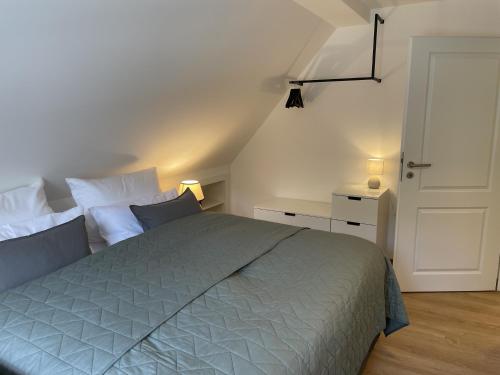 a bedroom with a large bed and a white door at Spreewaldhaus am Landgut - Pretschen in Markische Heide