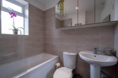 La salle de bains est pourvue de toilettes, d'un lavabo et d'une baignoire. dans l'établissement Little Nye, à Milford on Sea
