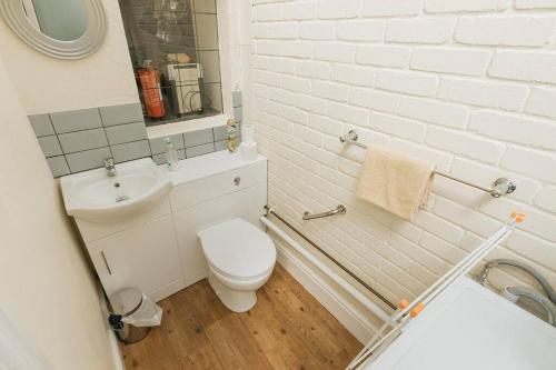 a white bathroom with a toilet and a sink at FIR TREE COTTAGE - Cosy 3 Bed Cottage in Penrhyn Bay with Beautiful Sea Views and Access to Snowdonia in Llandrillo-yn-Rhôs