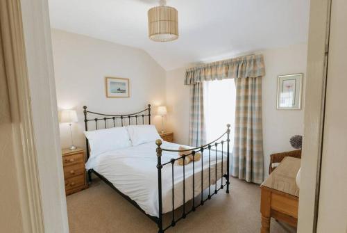 1 dormitorio con cama y ventana en FIR TREE COTTAGE - Cosy 3 Bed Cottage in Penrhyn Bay with Beautiful Sea Views and Access to Snowdonia, en Llandrillo-yn-Rhôs