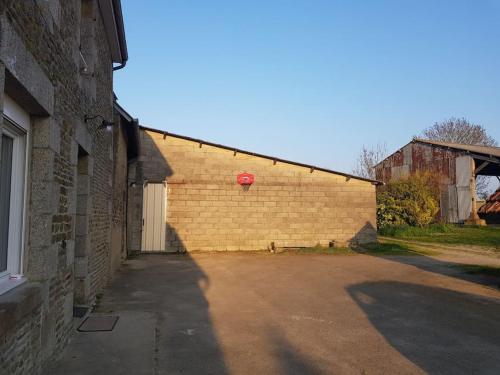 a brick wall with a red basketball hoop on it at La grange de Victor 12/14 pers - Mont-Saint-Michel in Céaux