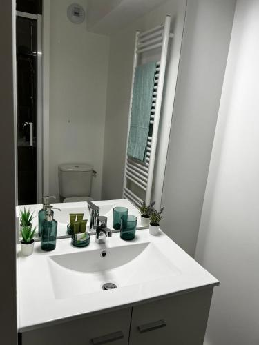 une salle de bain avec un lavabo blanc et un miroir dans l'établissement Neoresid Paris-Gagny, à Gagny