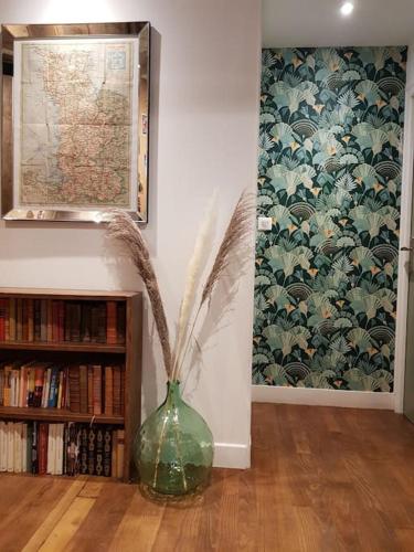 a vase with flowers in a room with a book shelf at La grange de Victor 12/14 pers - Mont-Saint-Michel in Céaux