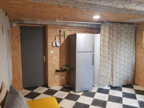 a kitchen with a refrigerator and a checkered floor at La grange de Victor 12/14 pers - Mont-Saint-Michel in Céaux
