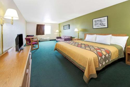 a hotel room with a large bed and a television at Super 8 by Wyndham Bonne Terre in Bonne Terre