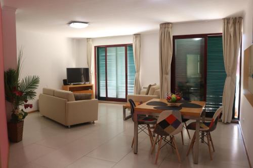 a living room with a dining room table and chairs at Garajau Terrace Orchids in Caniço