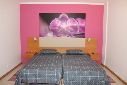 1 dormitorio con 1 cama con pared de color púrpura y rosa en Garajau Terrace Orchids, en Caniço