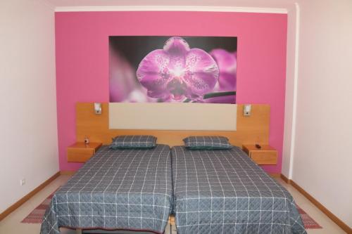 a bedroom with a bed with a purple and pink wall at Garajau Terrace Orchids in Caniço