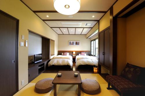 a hotel room with two beds and a couch at Oyado Ikegami in Uozu