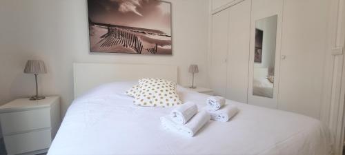 a bedroom with a white bed with towels on it at Little Suite - Benoît in Lille