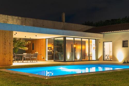 a house with a swimming pool at night at Populo's Place in Ponta Delgada