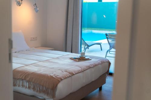 a bedroom with a bed and a view of a pool at Populo's Place in Ponta Delgada