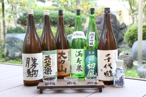 a group of wine bottles on a table with glasses at Oyado Ikegami in Uozu