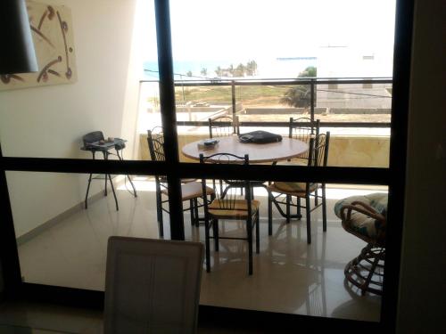 a table and chairs in a room with a balcony at Apartamentos Santiago - Maio in Vila do Porto