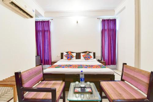 FabHotel Gitanjali في جايبور: غرفة نوم بسرير وكرسيين وطاولة