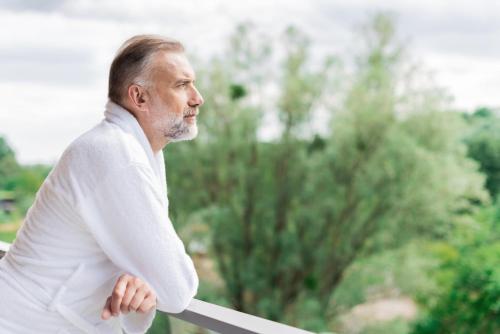 an older man standing on a railing lookingensive at Sopotorium Hotel & Medical Spa in Sopot