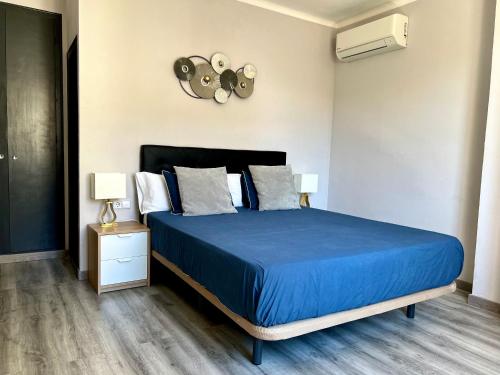 a bedroom with a blue bed and a clock on the wall at Hostal La Canonja in Tremp