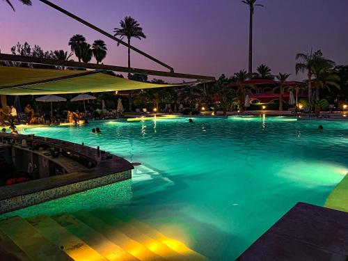 a pool with people swimming in it at night at Sakkara Country Club in Cairo