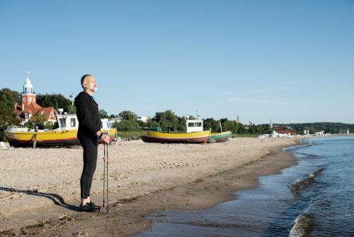 an older man is standing on the beach at Sopotorium Hotel & Medical Spa in Sopot