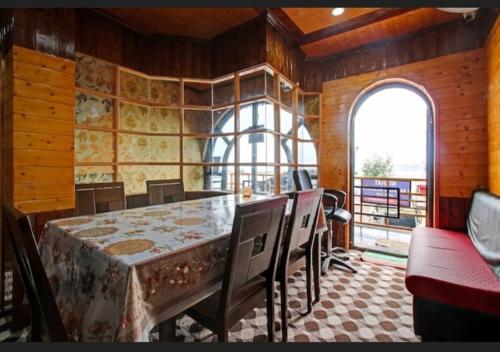 a dining room with a table and chairs and a window at Tiramisu Inn By 29bungalow in Srinagar