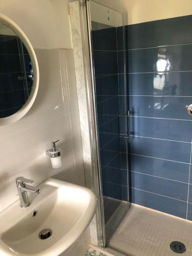 ein Bad mit einem Waschbecken und einer Dusche mit einem Spiegel in der Unterkunft B&B La Marinella in Palinuro