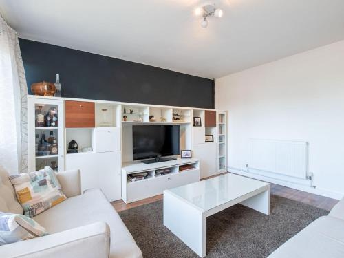 a living room with a white couch and a tv at Pass the Keys - Modern and spacious flat in South Central London in London