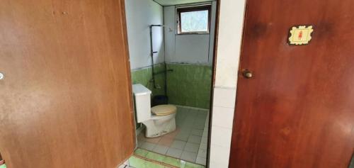 a small bathroom with a toilet and a door at Mulu Homestay in Mulu