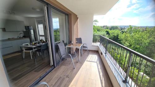 a balcony with a kitchen and a table with chairs at Vila Primorka Apartmani Oleander in Šilo